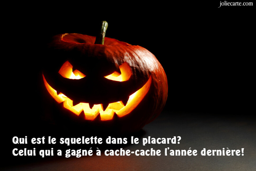 Une citrouille d'Halloween sculptée avec un visage effrayant et malicieux, brillamment illuminée de l'intérieur, se détachant sur un fond complètement noir.
